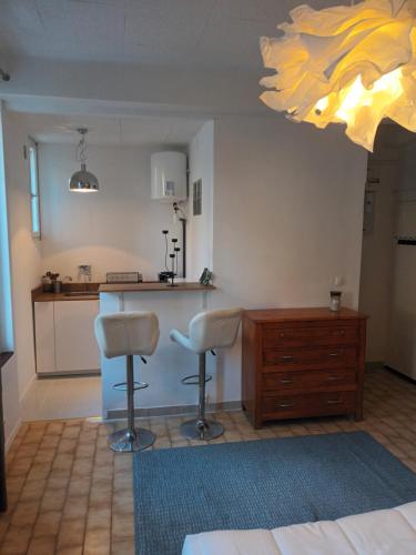 - une cuisine avec un comptoir et deux tabourets dans une pièce dans l'établissement Studios à 50 m des plages du Mourillon, à Toulon