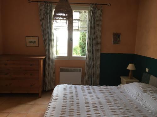 une chambre avec un lit blanc et une fenêtre dans l'établissement Gîte avec piscine Mes Vacances en Provence à Beaumes de Venise, à Beaumes-de-Venise