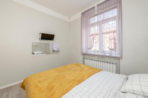una camera bianca con un letto e una finestra di Main street apartments SELF CHECK IN 24/7 by H&H a Vilnius