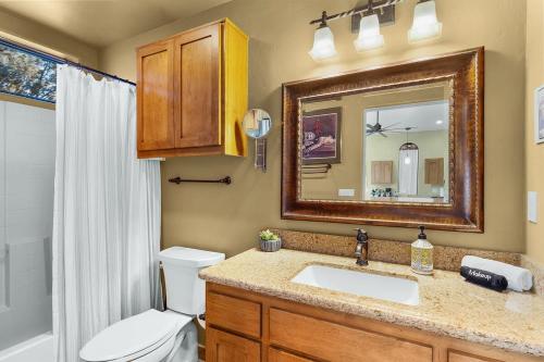 a bathroom with a sink and a toilet and a mirror at Mammoth Rock Retreat Villa-Sleeps 4 in Sedona