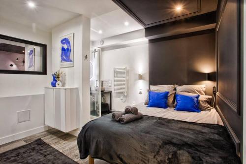 ein Schlafzimmer mit einem großen Bett mit blauen Kissen in der Unterkunft Deauville Luxury Blue Loft - sauna and inside pool in Trouville-sur-Mer