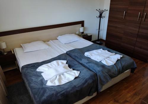 1 dormitorio con 1 cama y 2 toallas blancas en Family 2 bed Apartment in Bansko en Bansko