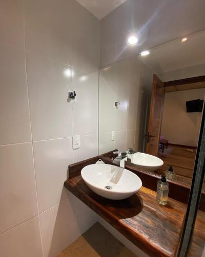 a bathroom with two sinks and a mirror at Chalé Antúrios - Lavras Novas in Lavras Novas