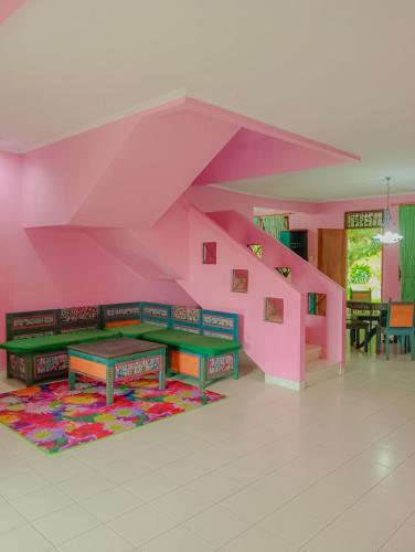 Habitación con escalera de color rosa, mesa y alfombra. en Villa family Montana 3, en Cicadas