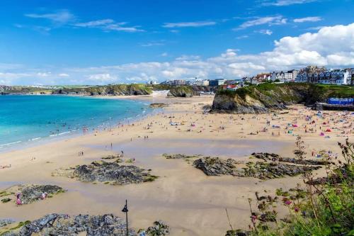 un grupo de personas en una playa cerca del océano en "The Penthouse Newquay" by Greenstay Serviced Accommodation - Stunning 3 Bed Apt With Parking & Sun Terrace - The Perfect Choice For Families, Small Groups & Business Travellers - Newly Refurbished - Close To Beaches, Shops & Restaurants, en Newquay