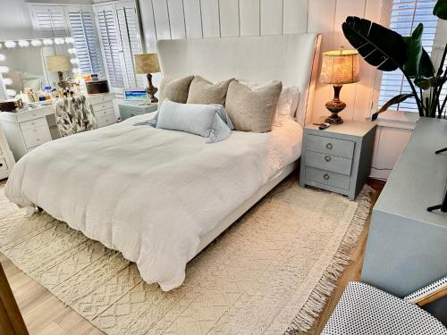 a bedroom with a large white bed with pillows at Balboa Island Beach Cottage with Golf Cart in Newport Beach