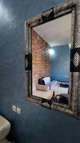 een spiegel aan een muur in een slaapkamer bij Hotel camping le Soleil Tinghir in Tinerhir