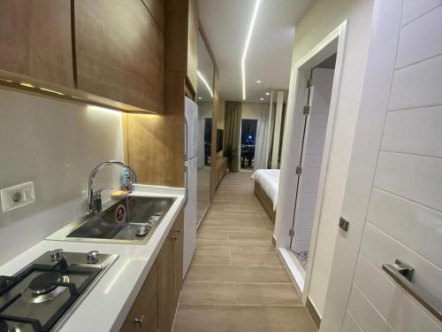 a kitchen with a sink and a hallway with a bed at Beach Experience Get-Away! in Trâblous