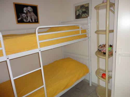 - une chambre avec 2 lits superposés et des draps jaunes dans l'établissement OREE DU GOLF II Agréable T3 traversant piscine côté golf Richelieu Cap d'Agde, au Cap d'Agde