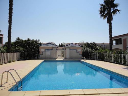 une piscine devant une maison dans l'établissement OREE DU GOLF II Agréable T3 traversant piscine côté golf Richelieu Cap d'Agde, au Cap d'Agde
