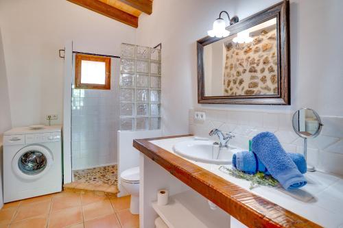 uma casa de banho com um lavatório e uma máquina de lavar roupa em Casita de Montaña cerca del mar em Fornalutx