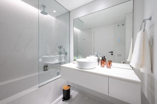uma casa de banho branca com 2 lavatórios e um chuveiro em Mirabilis Apartments - LX Living em Lisboa