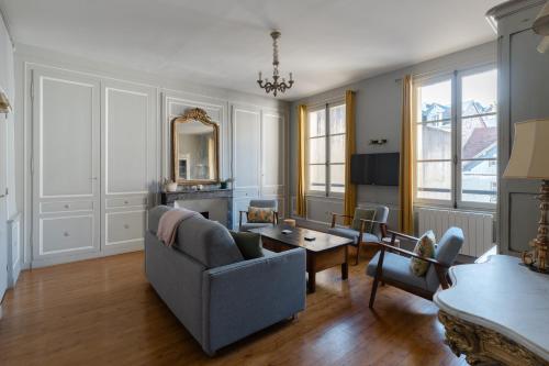 uma sala de estar com um sofá e uma mesa em Appartements Du Clos Vorin em Honfleur