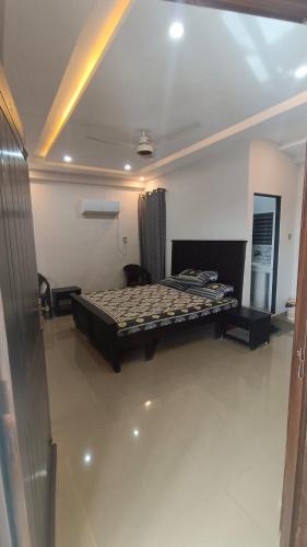 ein Schlafzimmer mit einem Bett in der Mitte eines Zimmers in der Unterkunft GSS TOWER HOTEL in Lahore