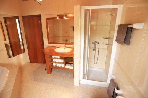 a bathroom with a sink and a shower and a tub at The Blue Eden in São João