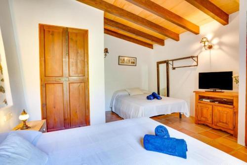 a bedroom with two beds and a television in a room at Casita de Montaña cerca del mar in Fornalutx