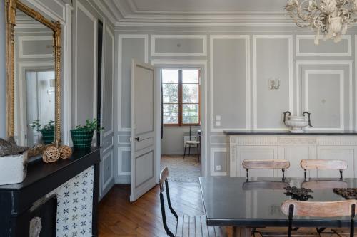 a dining room with a table and a mirror at Appartements Du Clos Vorin in Honfleur