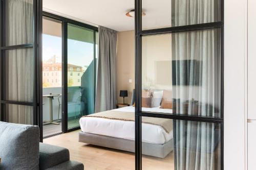 um quarto de hotel com uma cama e uma varanda em Mirabilis Apartments - LX Living em Lisboa