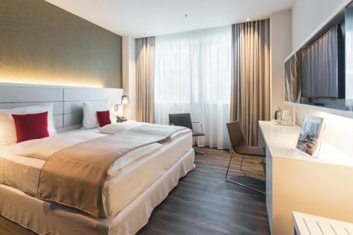a hotel room with a large bed and a large window at Riu Plaza Berlin in Berlin