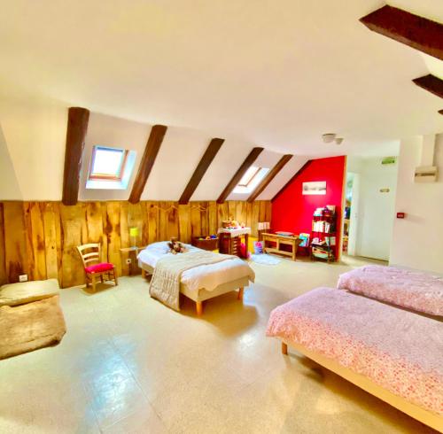 a bedroom with two beds and a red wall at Gîte Béthel in Lachamp-Raphaël