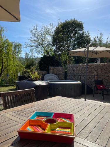 a tray sitting on a wooden table with an umbrella at LUVA d'Azur, Rez de villa LE RIOU - LE VALLON in Le Bar-sur-Loup
