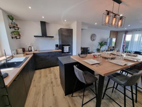 une cuisine avec une grande table en bois et des chaises dans l'établissement La Tanière de la baie - Maison 6-8 pers, à Le Val-Saint-Père