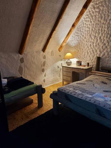 a bedroom with a bed and a desk in a attic at Cabin Hill Station Queen in Sarajevo