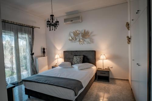 1 dormitorio con cama y ventana grande en Albireo Luxury Villa, en La Canea