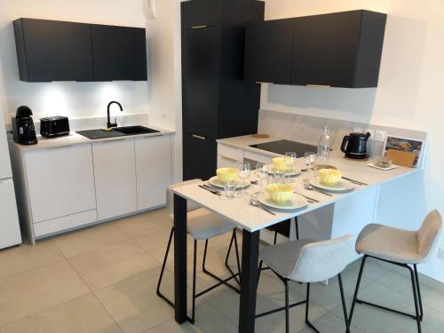 une cuisine avec une table avec des verres à vin dessus dans l'établissement T2 - 1 ch - Garage privé - Balcon - 15 min du lac, à Annecy