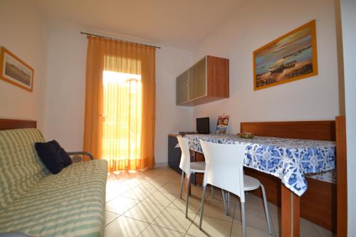 a living room with a table with chairs and a couch at Villa Poli in Bibione