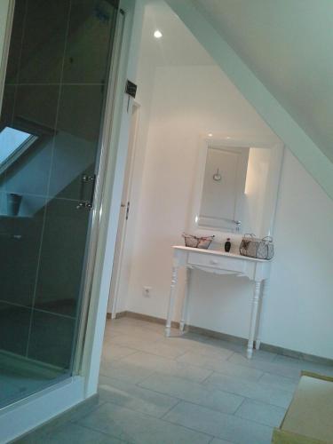a bathroom with a white table and a mirror at Maison Chauvin in Château-du-Loir
