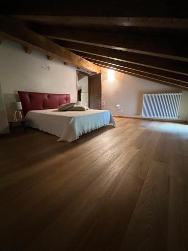 a bedroom with a bed and a wooden floor at Locanda Fermento in Mochignano