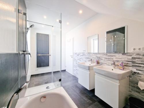 uma casa de banho branca com 2 lavatórios e um chuveiro em RAJ Living - 4 Room Apartments - 30 Min Messe DUS em Neuss