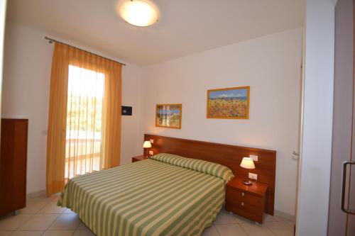 a hotel room with a bed and a window at Villa Poli in Bibione