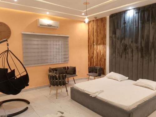 a bedroom with a bed and chairs in a room at Bénin Booking Buddy in Cotonou