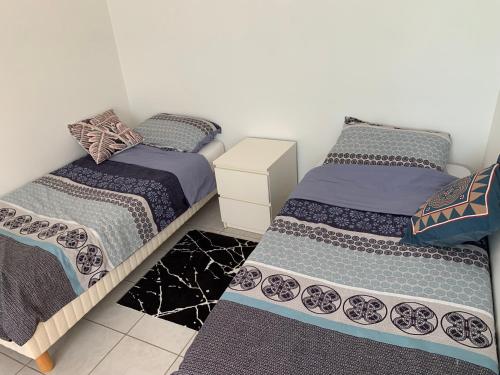 two twin beds in a room with at Chaleureux logement familial jusqu'à 6 personnes in Annemasse