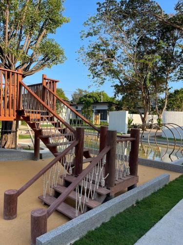 a wooden staircase in a park with trees at The Season Resort in Ban Chamrung