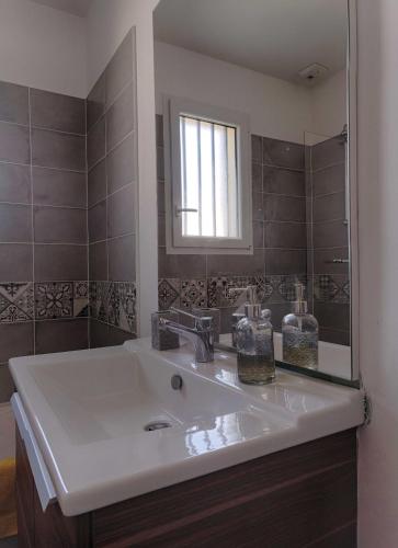 une salle de bain avec un lavabo et un miroir dans l'établissement Le Logis d'Emeric avec paisible jardin Clos&Arboré, à Loches