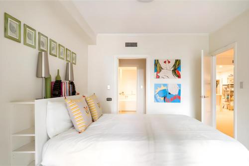 - une chambre blanche avec un grand lit blanc dans l'établissement XQ Collection Tiger's Place, Mascot, à Sydney