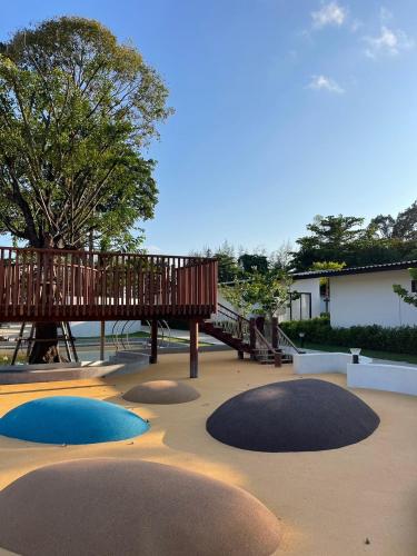 a playground with a wooden bridge and a wooden deck at The Season Resort in Ban Chamrung
