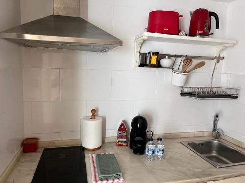 a kitchen counter top with a sink and a stove at Casa Beco Do Castelo in Lisbon