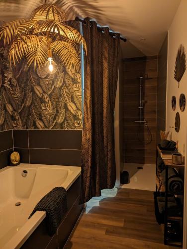 a bathroom with a bath tub and a shower at la Pléiade in Pont-Hébert