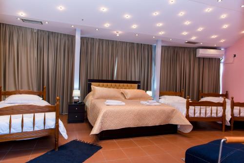 a large bedroom with two beds and curtains at Hotel Blue Eye in Korçë