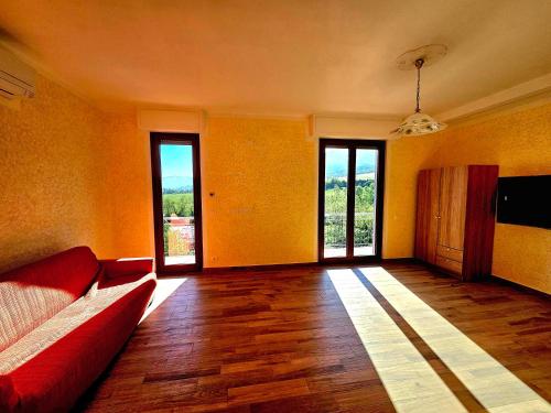 a living room with a red couch and sliding glass doors at Guest House Fantaccini in Pelago