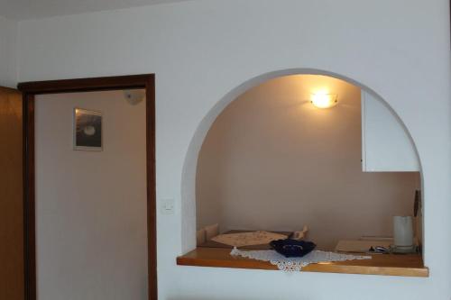 a room with an arch with a light on the wall at Apartmani Marija Mljet in Sobra