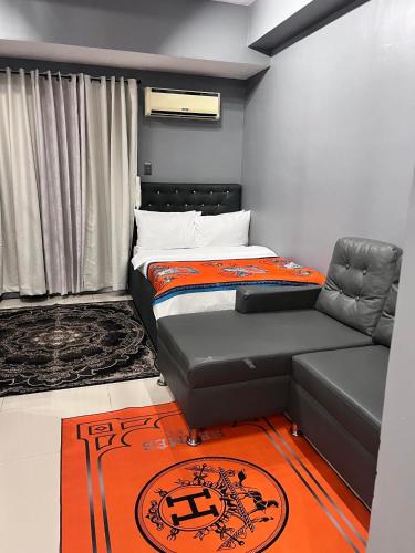 1 dormitorio pequeño con 1 cama y 1 sofá en J&J Staycation at Grass Residence, en Manila