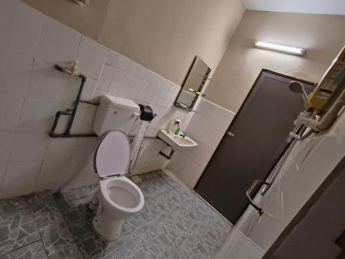 a small bathroom with a toilet and a shower at Pulai Homestay in Ipoh