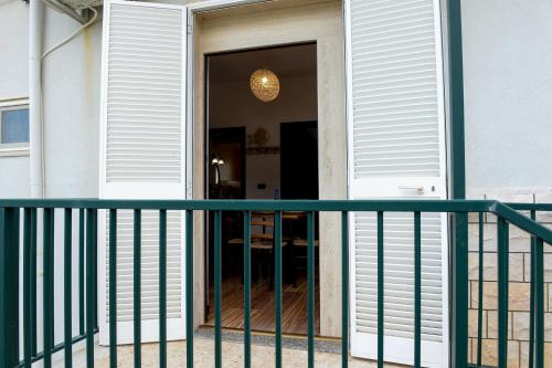 a front door of a house with a green railing at Casa Lisanna - Cozy apartment by the Sea in Capitolo