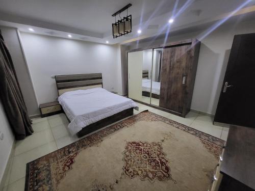 1 dormitorio con cama y espejo grande en شقه فندقيه بالدقي en El Cairo