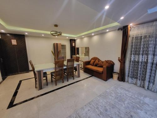 uma sala de estar com uma mesa e cadeiras e um sofá em شقه فندقيه بالدقي no Cairo